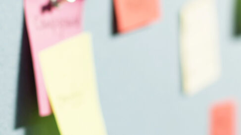 A series of post-it notes attached to a wall during a workshop